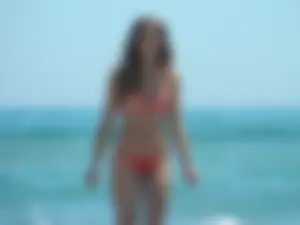 Sexy beach babe in orange thong and floral top