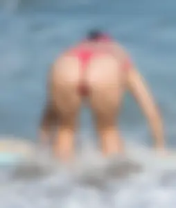 Thick brunette milf on the beach in red thong bikini