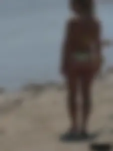 Sexy blonde on the beach in a yellow thong bikini
