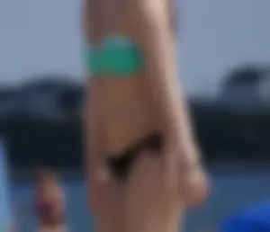 Sexy beach brunette in teal top and black bottom bikini