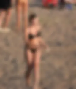 Cute Skinny Girl in Black Swimsuit on the Beach