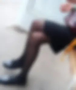 Skinny Tall Girl Sitting in the Bus Stop with Crossed Legs in Black Pantyhose