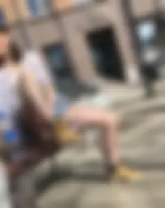Candid chick wearing denim shorts chilling on the street bench spreading her legs