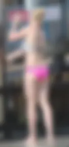 Skinny blonde girl on the beach in her pink and white bikini