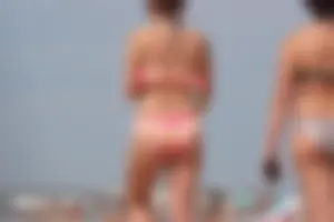 Trio of girls in bikinis on the beach and one with an incredible ass