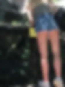 Low angle photo of a petite ass in fringed denim mini shorts and long slim legs