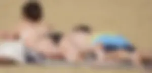 Sexy girl on the beach laying out and bending over in her bikini