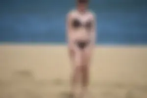 Chunky blonde in a black bikini on the beach