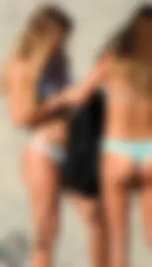 Two sexy friends on the beach in thong bikinis