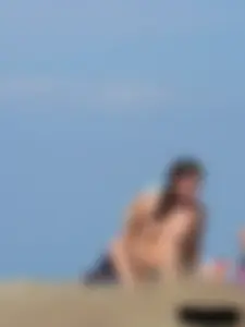 Sexy babe with a nice body topless and in a thong on the beach
