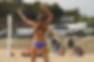 Sexy beach volleyball girl in sport bra top with pokies and blue bikini bottom