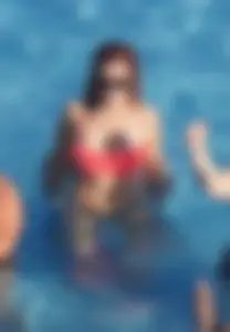 Sexy red haired girl in pink and black bikini at the pool