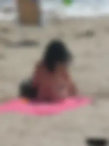 Brunette lady topless and in a black thong on the beach