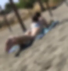 Hot skinny girl chilling on the beach wearing a swimsuit