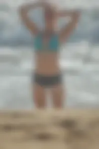 Blonde lady on the beach in bikini top and spandex shorts with a nice gap