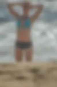 Blonde lady on the beach in bikini top and spandex shorts with a nice gap