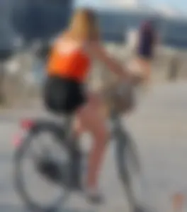 Blonde in black shorts getting on a bike
