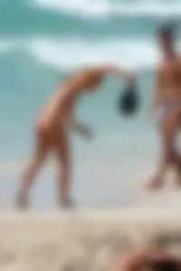 Topless girl in a tiny thong on the beach playing paddle ball