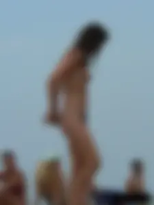 Sexy babe with a nice body topless and in a thong on the beach