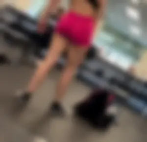 Bend over at gym in red shorts