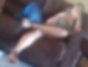 Girl in sandals and shorts sitting on the couch with crossed legs