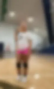 Bunch of cute college girls in bright pink shorts playing volleyball