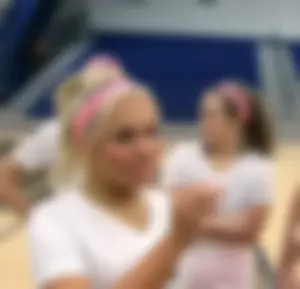 Bunch of cute college girls in bright pink shorts playing volleyball
