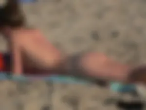 Sexy babe with a nice body topless and in a thong on the beach