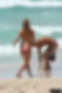 Topless girl in a tiny thong on the beach playing paddle ball