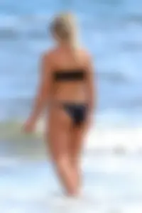 Beach blonde in the water in black bikini with a nice ass and small boobs
