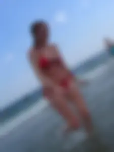 Sexy girl at the beach in a red thong bikini with nice tits and ass