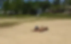 Sexy girl getting some sun laying on the beach in thong bikini