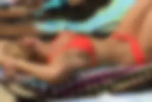 Sexy blonde lady in a bikini with a great body laying by the pool
