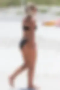 Beach blonde in the water in black bikini with a nice ass and small boobs
