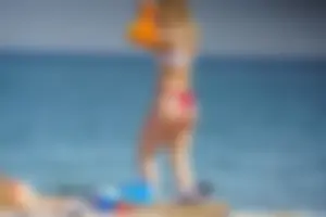 Hot blonde with a slammin body in red thong bikini on the beach