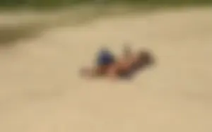 Sexy girl getting some sun laying on the beach in thong bikini
