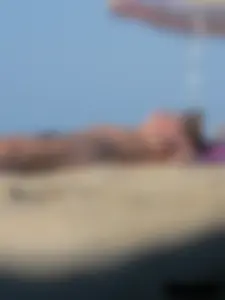 Sexy babe with a nice body topless and in a thong on the beach