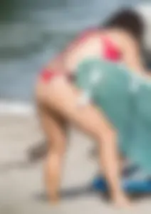 Thick brunette milf on the beach in red thong bikini