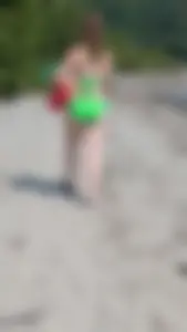 Beautiful Brown hair tight Girl in green bikini on the beach. oc