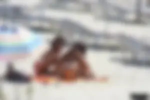 Topless milf and her topless daughter on the beach