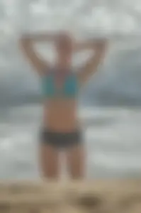 Blonde lady on the beach in bikini top and spandex shorts with a nice gap