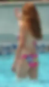 Skinny ginger in pink floral bikini in the pool