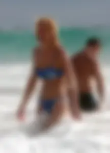 Blonde milf in a blue bikini looking sexy at the beach