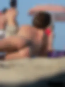 Sexy babe with a nice body topless and in a thong on the beach