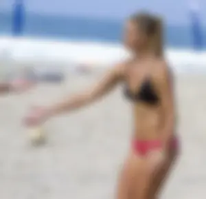 Hot girls playing beach volleyball in bikinis and shorts