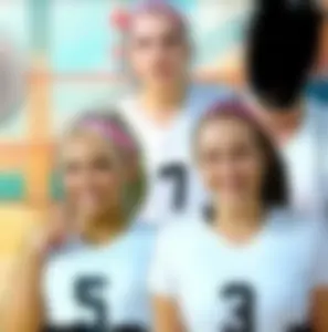 Bunch of cute college girls in bright pink shorts playing volleyball