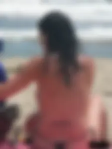Brunette lady topless and in a black thong on the beach