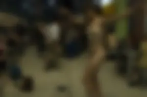 Awesome naked female dancer with a painted body on the street