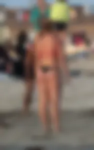 Thick white girls ass in a black thong bikini at the beach