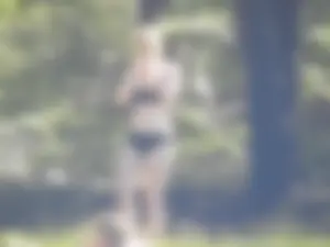 Two sexy friends in black bikinis laying out